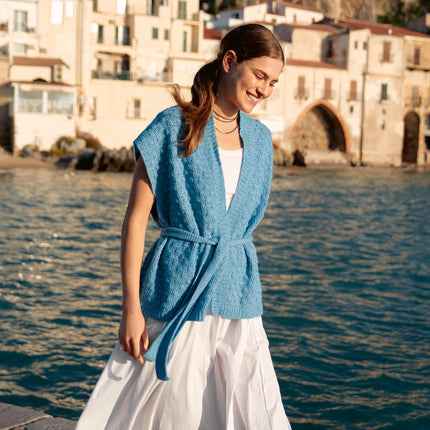 Garenkunst.nl, Haakpakket zomervest met Ecopuno Model 15 uit magazine Häkeln 09 van Lana Grossa. Elegant, zacht en moeiteloos stijlvol: dit zomervest met ceintuur is een verfijnd haakproject met een luxe uitstraling. Sfeerfoto gemaakt op Sicilie van de voorkant.