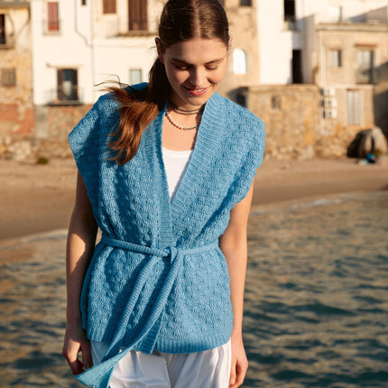 Garenkunst.nl, Haakpakket zomervest met Ecopuno Model 15 uit magazine Häkeln 09 van Lana Grossa. Elegant, zacht en moeiteloos stijlvol: dit zomervest met ceintuur is een verfijnd haakproject met een luxe uitstraling. Sfeerfoto gemaakt op Sicilie van de voorkant, dichtbij.