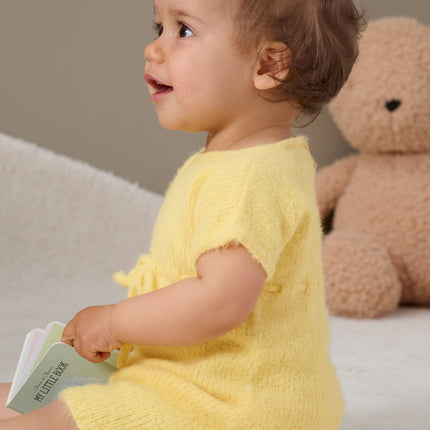 Breipakket babyjurk model 14 Cosy Socks 4 Babies van Lana Grossa, lachend kindje, gele jurk