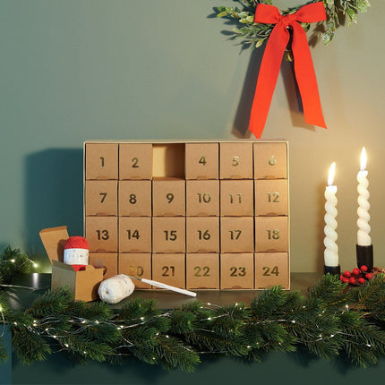Geopende Ricorumi adventskalender met garen en haaknaald op tafel